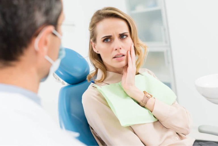 Patient holding their cheek in pain, seen the same day by a Geelong dentist